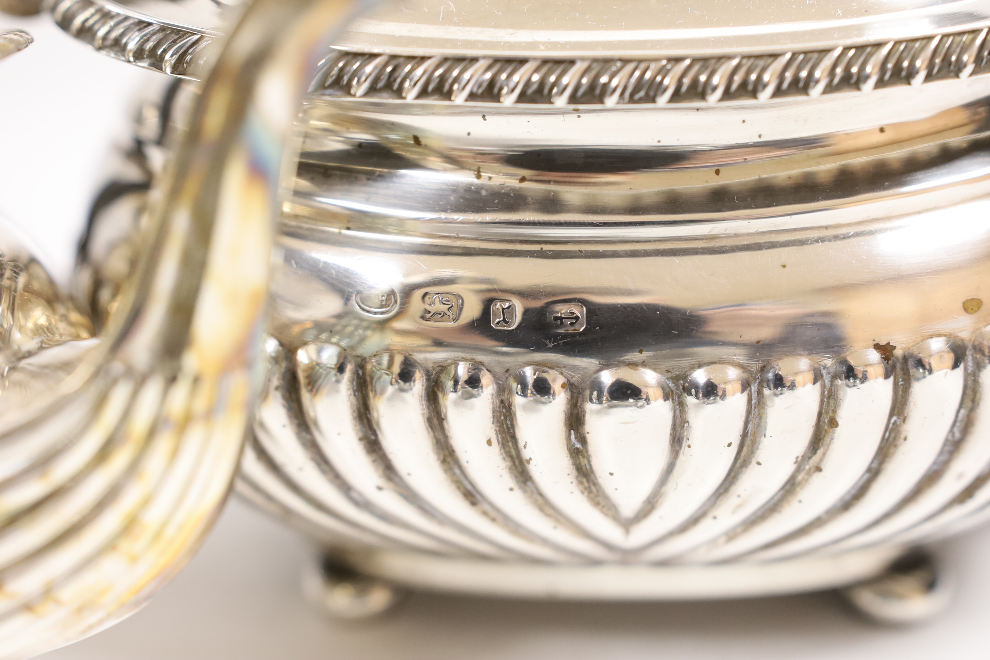A late Victorian demi fluted silver three piece tea set, William M. Hayes, Birmingham, 1897, together with another demi fluted silver teapot and sugar bowl, same maker, Birmingham, 1898, gross weight 52.6oz.